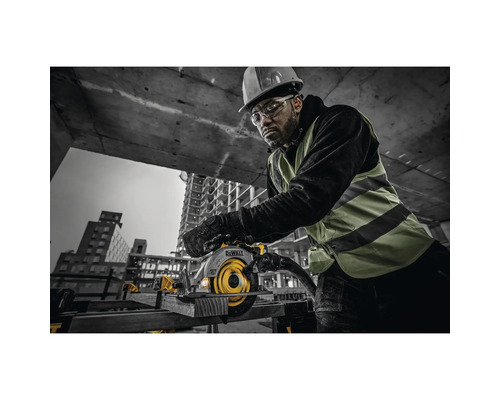Homme portant un casque et des lunettes de protection utilisant une scie circulaire portative de marque DeWalt sur un chantier