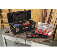 Boîte à outils ouverte avec des outils et un assortiment de petites pièces sur une table.