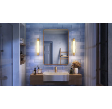 Salle de bains avec lavabo, miroir et éclairage sur mur carrelé