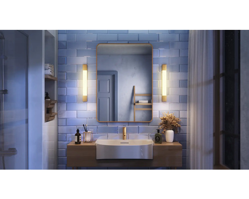 Salle de bains avec lavabo, miroir et éclairage sur mur carrelé