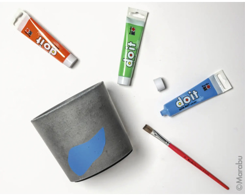 Betontopf mit Farbtuben und Pinsel