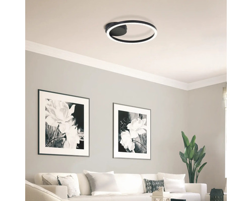 Salon avec plafonnier rond et images décoratives