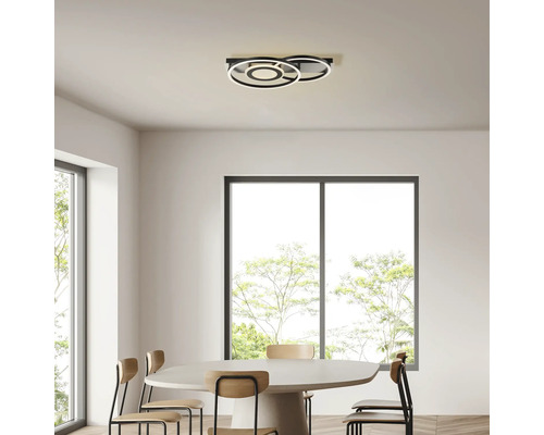 Plafonnier avec des éléments circulaires au-dessus d'une table à manger dans une pièce lumineuse.