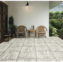 Terrasse mit zwei Rattanstühlen und kleinem Tisch auf Steinboden