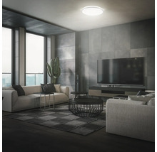 Modernes Wohnzimmer mit Couch, Fernseher und Deckenleuchte