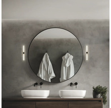 Salle de bain moderne avec double vasque, miroir rond, appliques murales et peignoirs