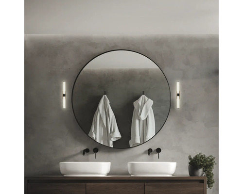 Salle de bain moderne avec double vasque, miroir rond, appliques murales et peignoirs