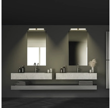 Salle de bain avec deux lavabos, miroirs, serviettes et étagères dans des tons foncés.