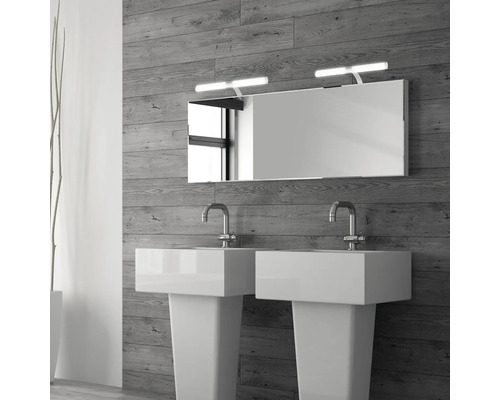 Badezimmer mit Doppelwaschbecken, Spiegel und Beleuchtung vor einer Holzwand