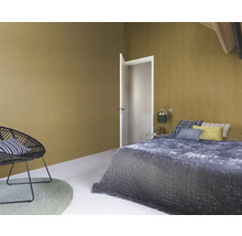 Schlafzimmer mit Bett, Stuhl und strukturierten Wänden