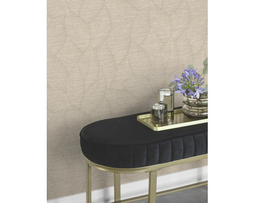 Eine Wand mit gemusterten Tapeten hinter einer Bank mit Blumen und Gläsern