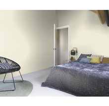 Chambre claire avec lit, fauteuil et porte