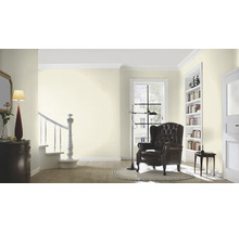 Salon lumineux avec fauteuil, bibliothèque et escalier