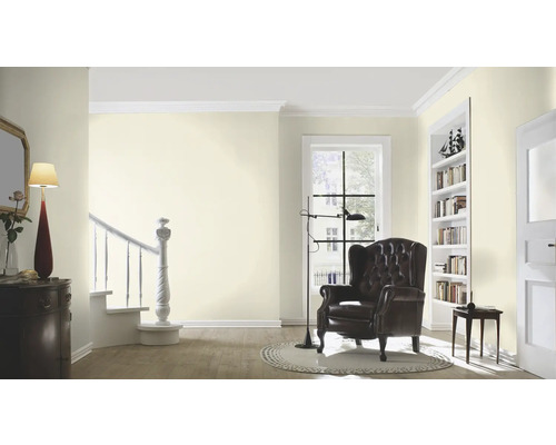 Salon lumineux avec fauteuil, bibliothèque et escalier
