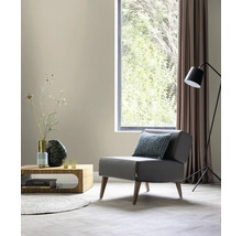 Salon avec fauteuil, table, lampadaire et fenêtre pour une atmosphère lumineuse et organisée.