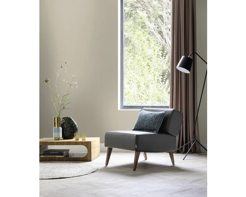 Wohnzimmer mit Sessel, Tisch, Stehlampe und Fenster für eine helle und organisierte Atmosphäre.