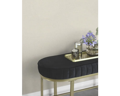 Dekorativer Hocker mit Blumen, Gläsern und goldenem Tablett.