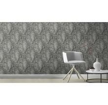 Scène avec un papier peint imprimé de reliefs d'éléphants, une chaise et une table avec décoration