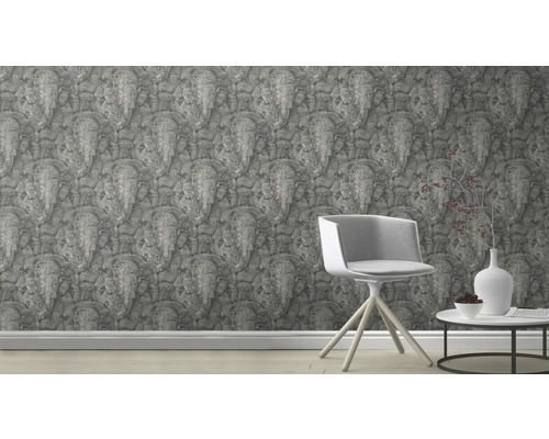 Szene mit einer mit Elefantenreliefs bedruckten Tapete, einem Stuhl und einem Tisch mit Dekoration