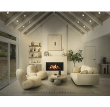 Heller Wohnraum mit Kamin, Sesseln, Sofa und Regalen.