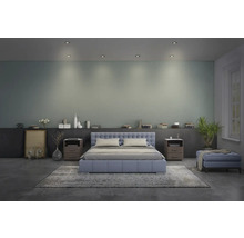 Schlafzimmer mit Bett, Nachttischen und dekorativen Elementen.