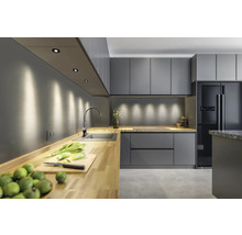 Moderne Küche mit grauen Schränken, Holzarbeitsplatte und Einbauspots