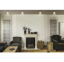 Wohnzimmer mit Kamin, Sesseln und dekorativen Elementen für eine gemütliche Atmosphäre.