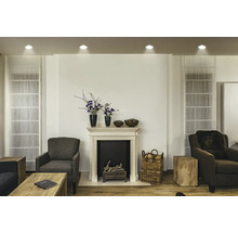 Wohnzimmer mit Kamin, Sesseln und dekorativen Elementen für eine gemütliche Atmosphäre