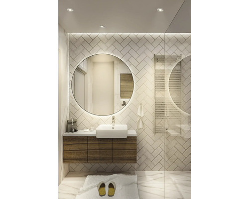 Helles Badezimmer mit Waschtisch, rundem Spiegel und Handtuchwärmer