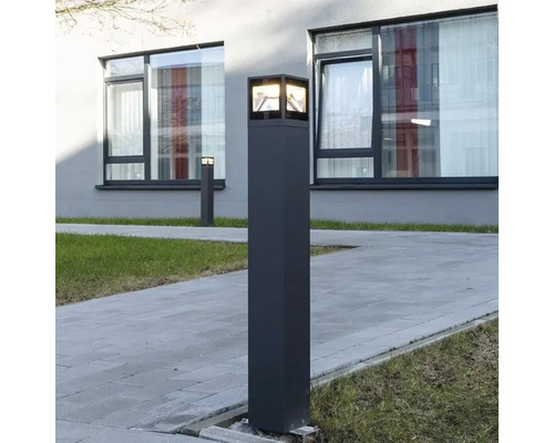 Aussenleuchte in Säulenform neben einem gepflasterten Weg.