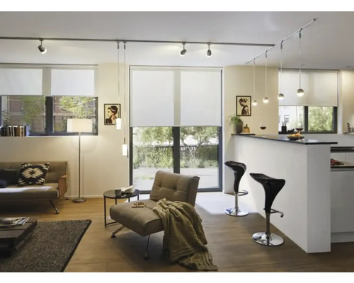 Espace de vie lumineux avec canapé, fauteuil, stores et système d'éclairage