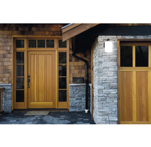 Extérieur d'une maison avec porte en bois, mur en pierre et gouttière