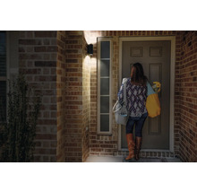 Frau steht vor Haustür mit Aussenleuchte