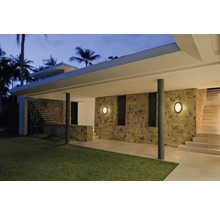 Espace extérieur avec mur en pierre, escalier et deux appliques murales rondes