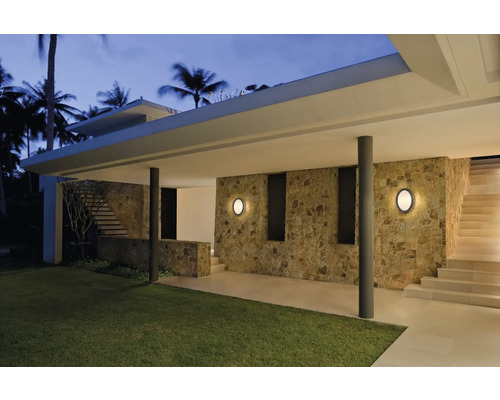 Espace extérieur avec mur en pierre, escalier et deux appliques murales rondes