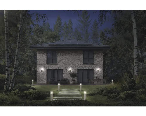 Maison d'habitation éclairée avec allée de jardin et luminaires extérieurs de nuit