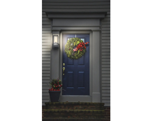 Porte d'entrée avec couronne de Noël, lampe d'extérieur et décoration en pot