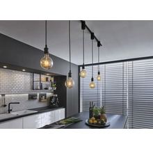Cuisine moderne avec table à manger et plafonnier avec plusieurs suspensions