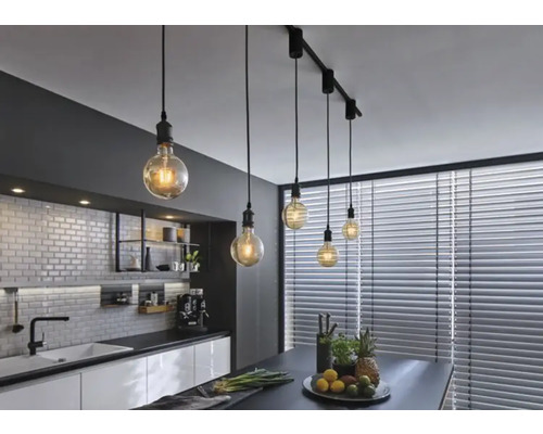 Cuisine moderne avec table à manger et plafonnier avec plusieurs suspensions