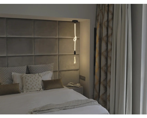 Schlafzimmer mit Bett, Nachttisch, Vorhängen und einer dekorativen Leuchte