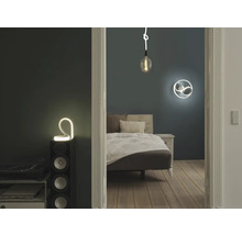 Schlafzimmer mit Bett, Nachttisch und dekorativer Beleuchtung