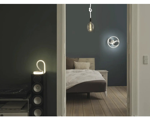 Schlafzimmer mit Bett, Nachttisch und dekorativer Beleuchtung