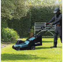 Un homme utilise une tondeuse à gazon Makita dans le jardin
