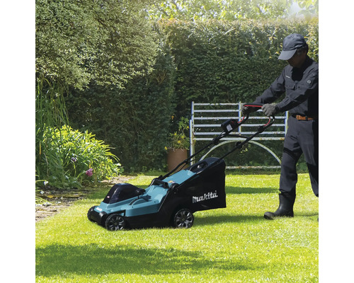 Un homme utilise une tondeuse à gazon Makita dans le jardin