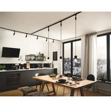 Cuisine moderne avec kitchenette noire, table en bois et système de rail noir avec spots et suspensions