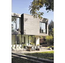 Modernes Haus mit Holzfassade, großen Fenstern und Terrasse mit Gartentisch und Stühlen