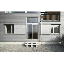 Fassade eines Hauses mit Holzverkleidung, Fenstern, Schiebeläden und Eingangstür