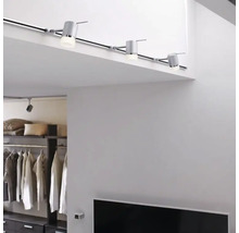 Intérieur avec système d'éclairage sur rail au plafond et système d'étagères en arrière-plan.