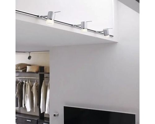 Intérieur avec système d'éclairage sur rail au plafond et système d'étagères en arrière-plan.