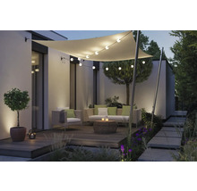 Terrasse aménagée avec voile d'ombrage, guirlande lumineuse et salon de jardin.